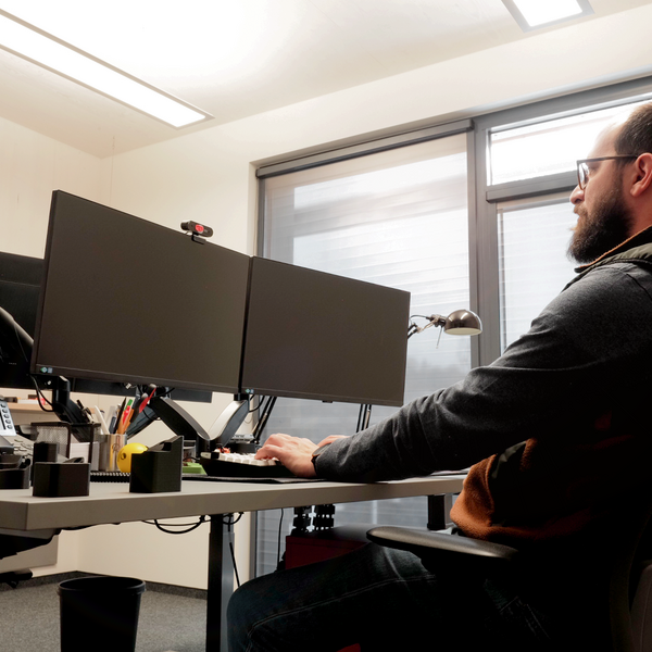 Workstation in the Mogatec GmbH development department with a RHODESHADE roller shade, free of glare