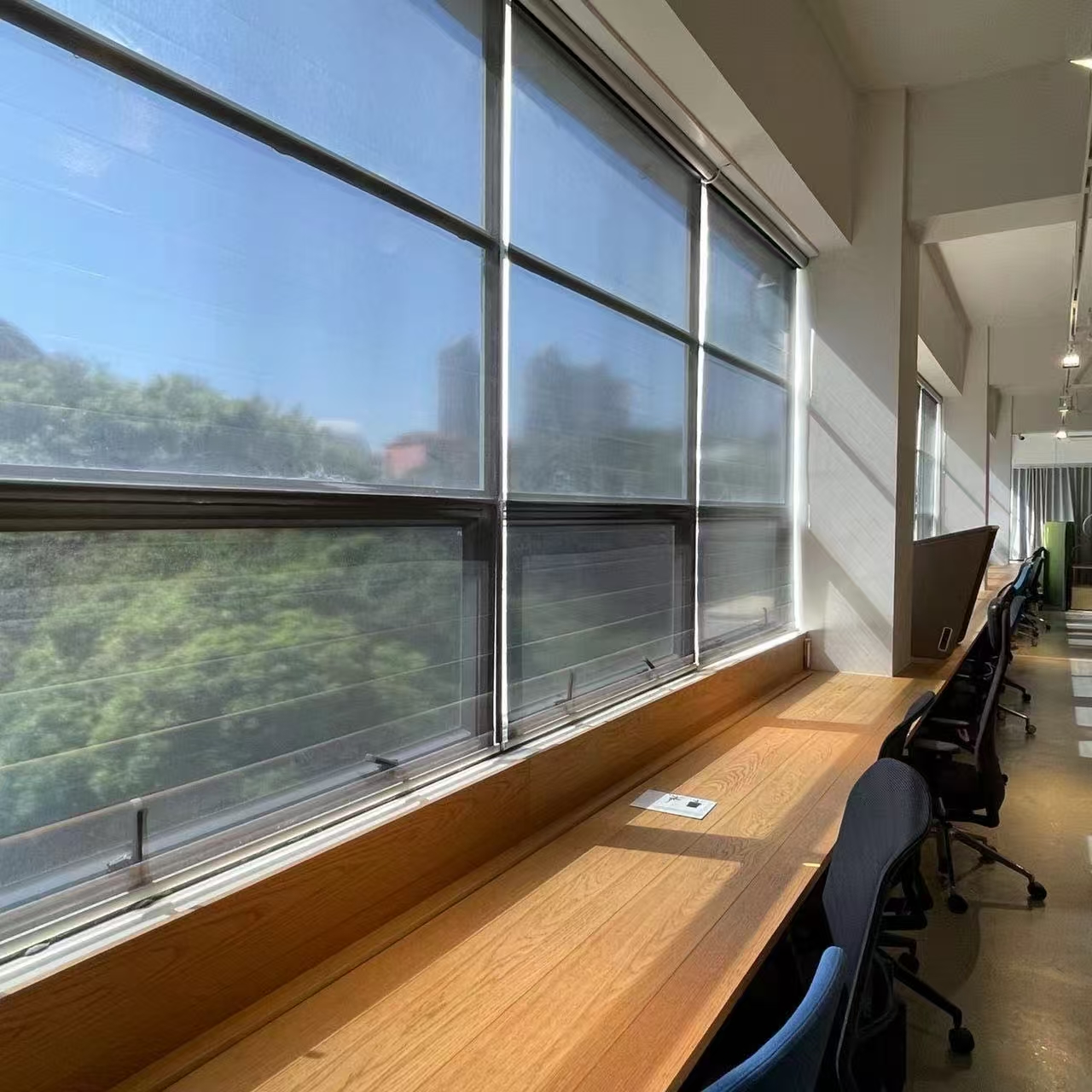 Workstations at Shenzhen Nei Tian Office with roller shades along the window front