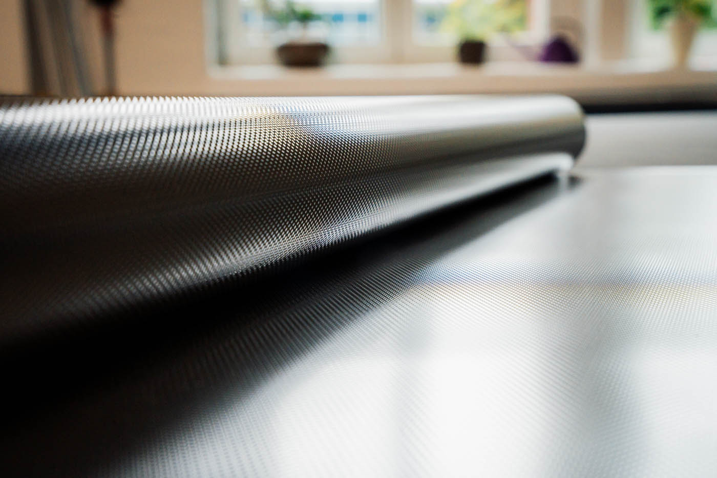 Close-up of a film roll with a shiny metallic surface on the work table