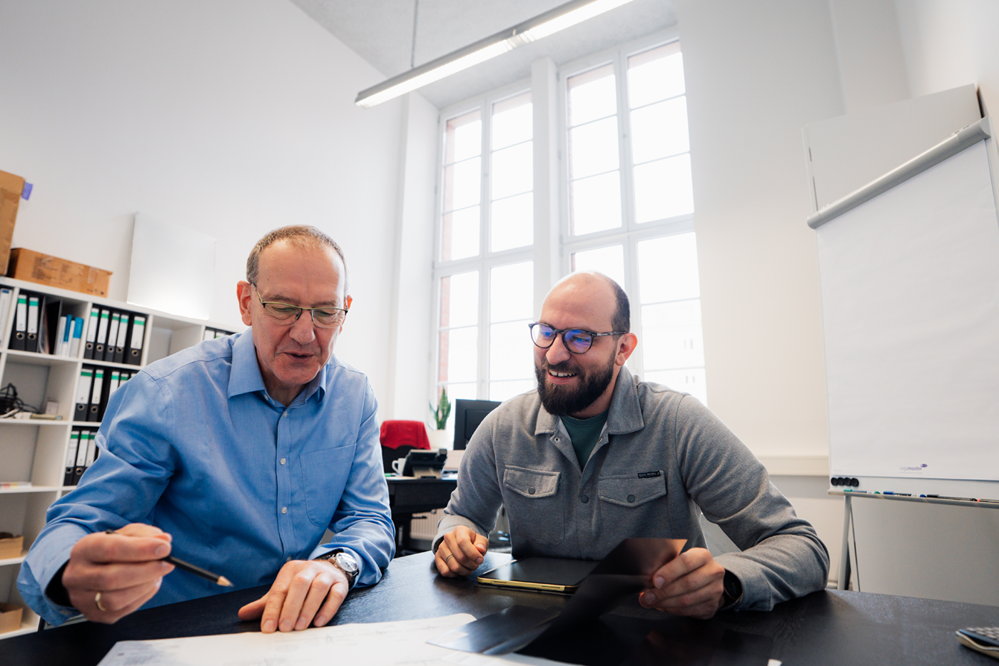 Two RHODETEC employees discussing a film sample at a table